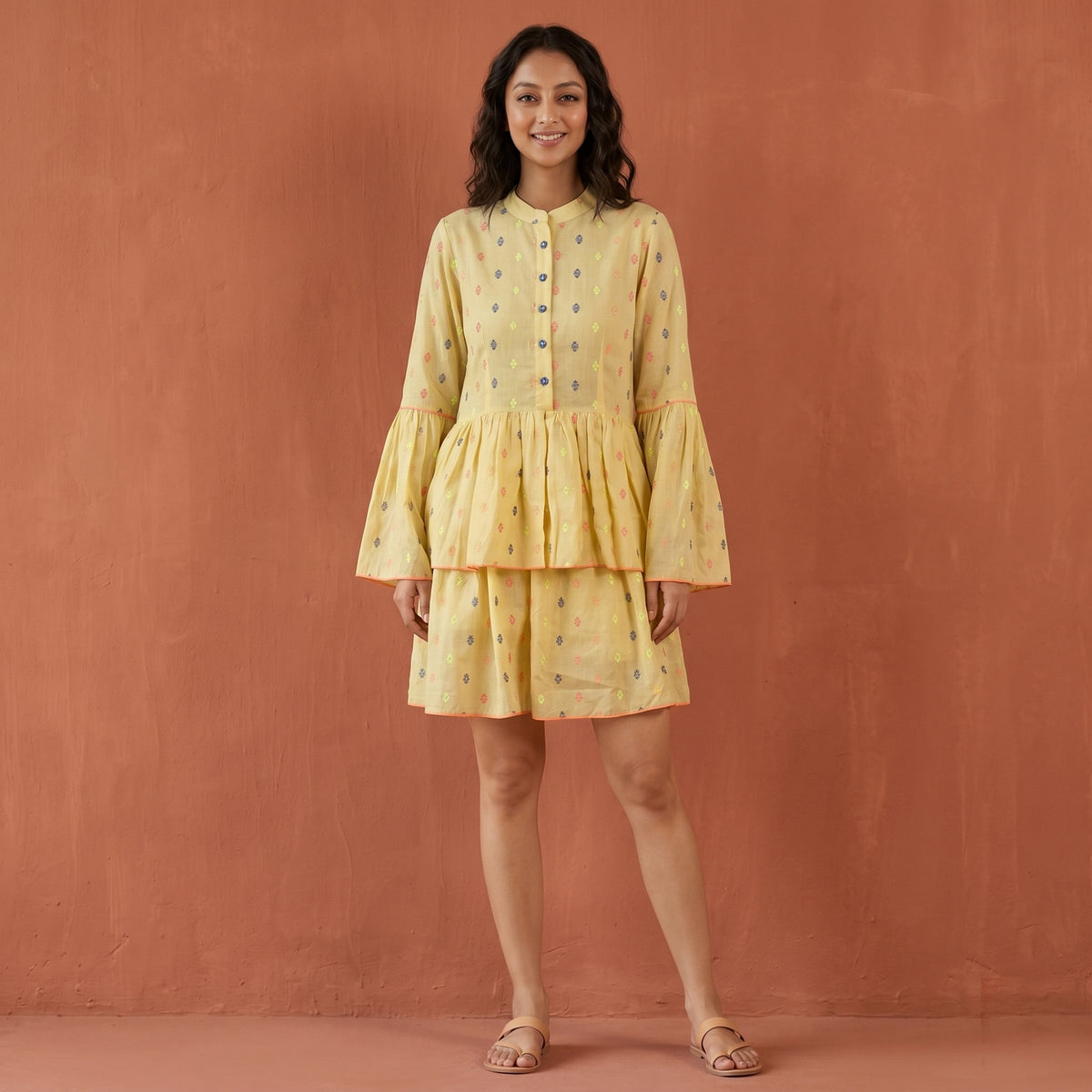 Lemon yellow tiered mini dress with a printed pattern, ruffled hem and flared bell sleeves